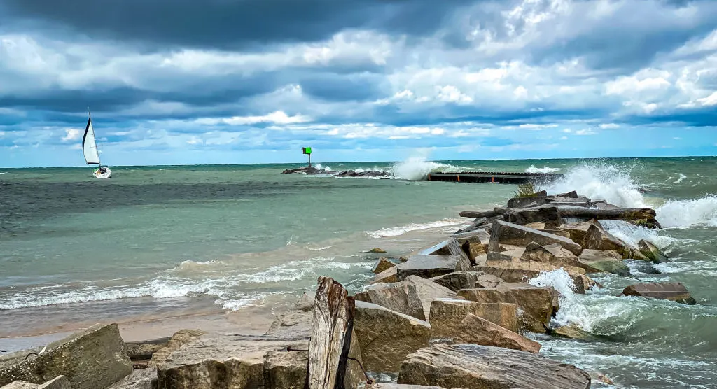 New Buffalo Boater & Lake Information Sailboat leaving New Buffalo River Channel during a blustery day with dark skies